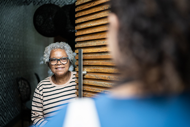 An elderly woman opening a door