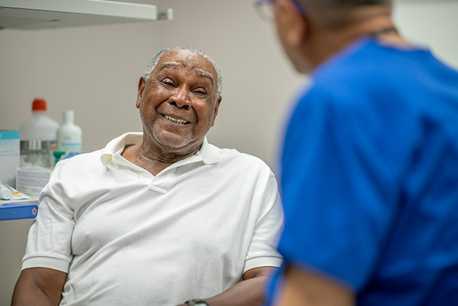 An elderly man talking to a nurse