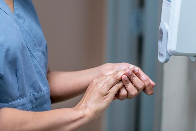 A nurse sanitising their hands
